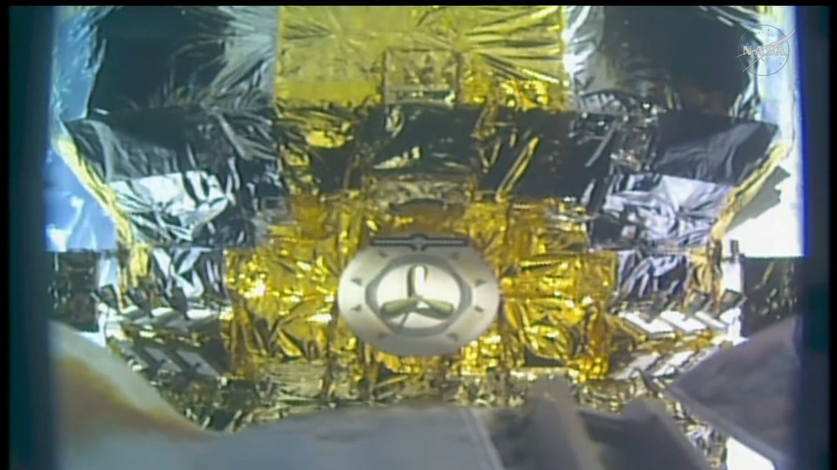 NASA TV still of the HTV-X1 cargo spacecraft, wrapped in gold and silver multi-layer insulation, seen up close from the ISS during capture operations.