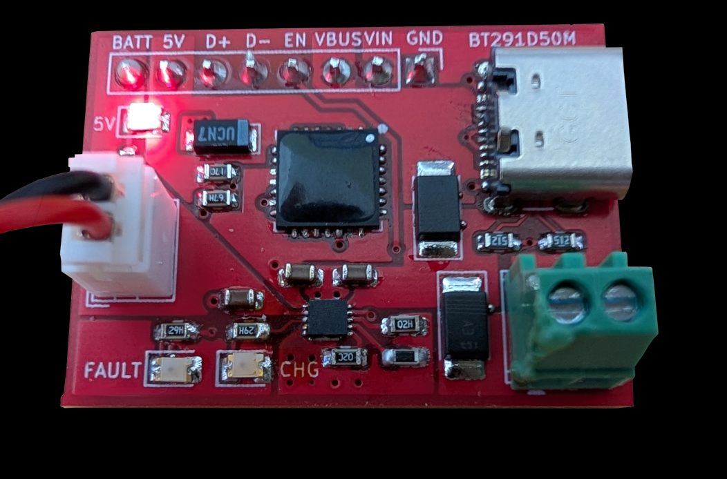 Red BT291D50M demonstration board with labeled BATT, 5V, D+, D-, EN, VBUS, VIN, and GND header pads, a USB-C connector, a green screw terminal, a white battery connector with red and black leads, and a lit red 5V indicator LED.